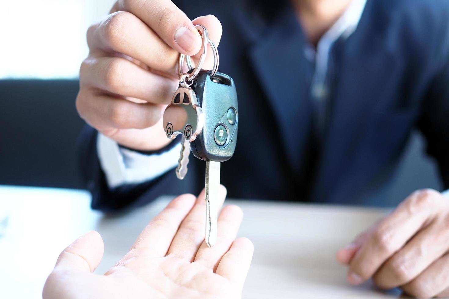 il auto venditore e il chiave per il nuovo proprietario. foto