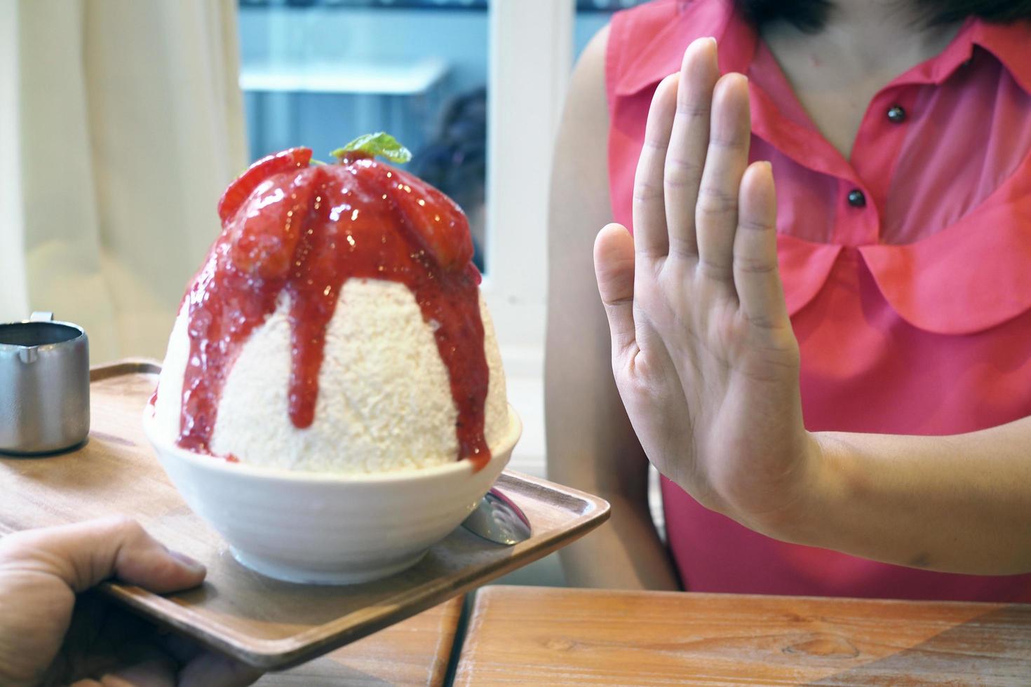 donne spingere bingsu tazza. rifiutato per mangiare tutti tipi di dolci. evitare zucchero e dolci per bene Salute. dieta concetto foto