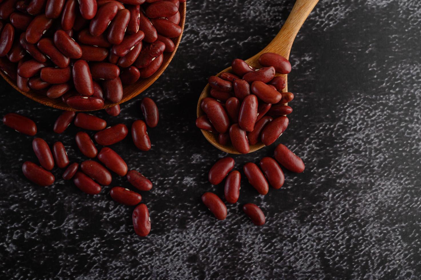 fagioli rossi in ciotole di legno sulla superficie della cucina nera foto