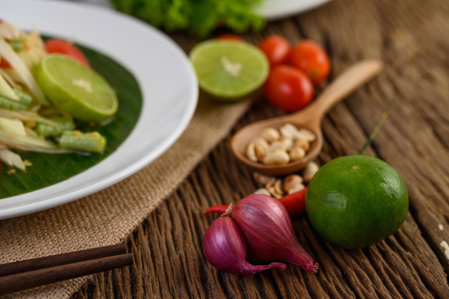 cibo piccante in stile tailandese con aglio, limone, arachidi, pomodori e scalogno foto