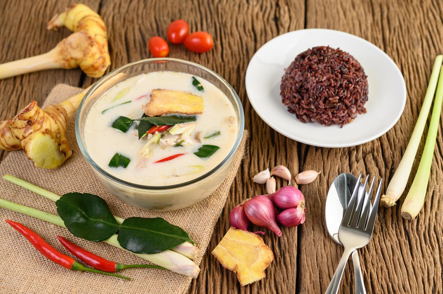 tom kha kai, zuppa di cocco tailandese sul bordo della cucina in legno foto