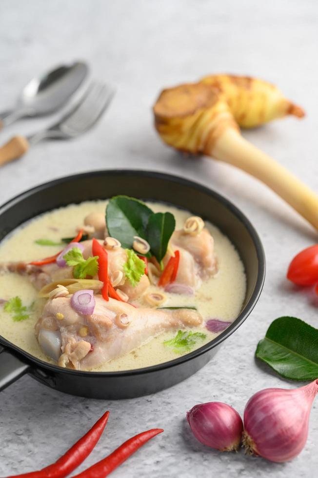 zuppa tom kha kai con foglie di lime kaffir, citronella, cipolla rossa, galanga e peperoncino foto