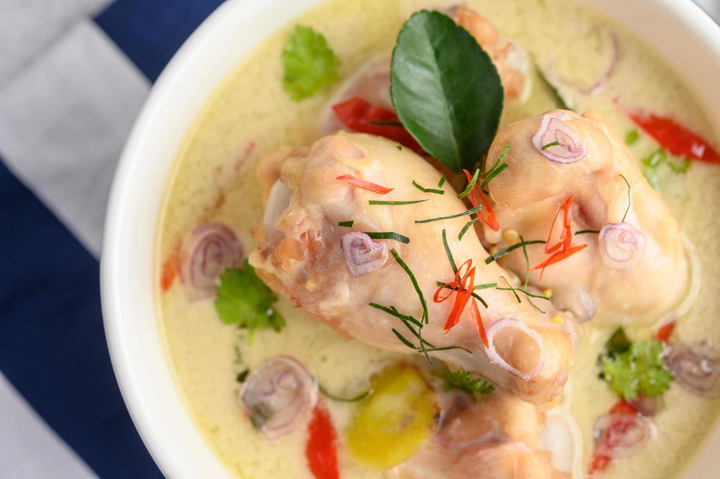 tom kha kai, zuppa di cocco tailandese su un panno a strisce blu foto