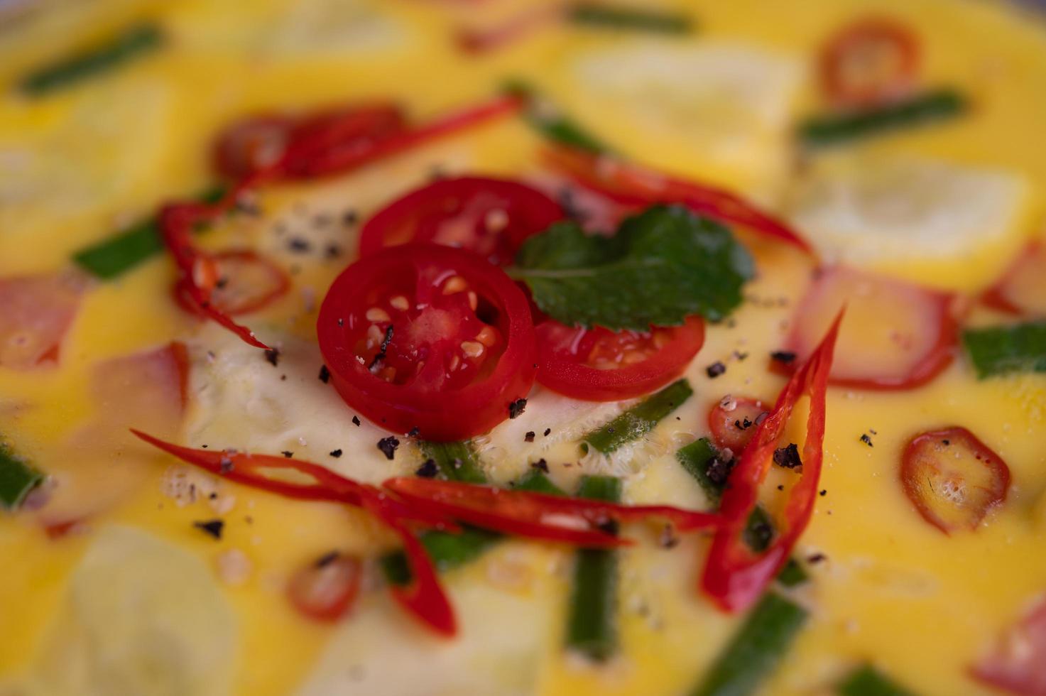 primo piano di uova al vapore con pancetta, peperoncino e cipolla verde foto