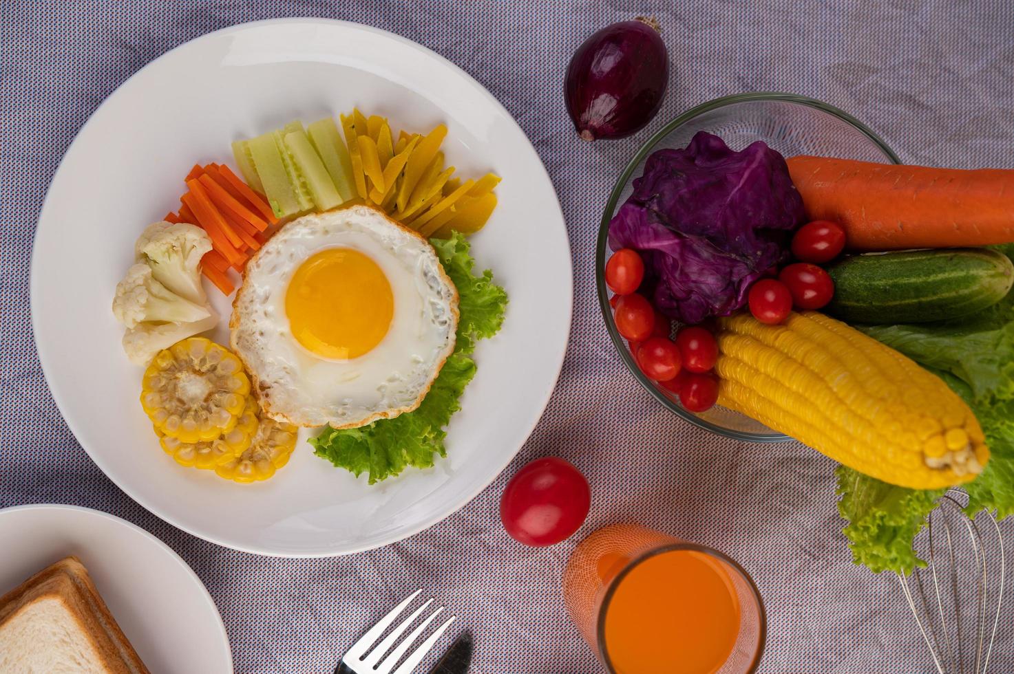 colazione uovo fritto con verdure e succo di frutta foto