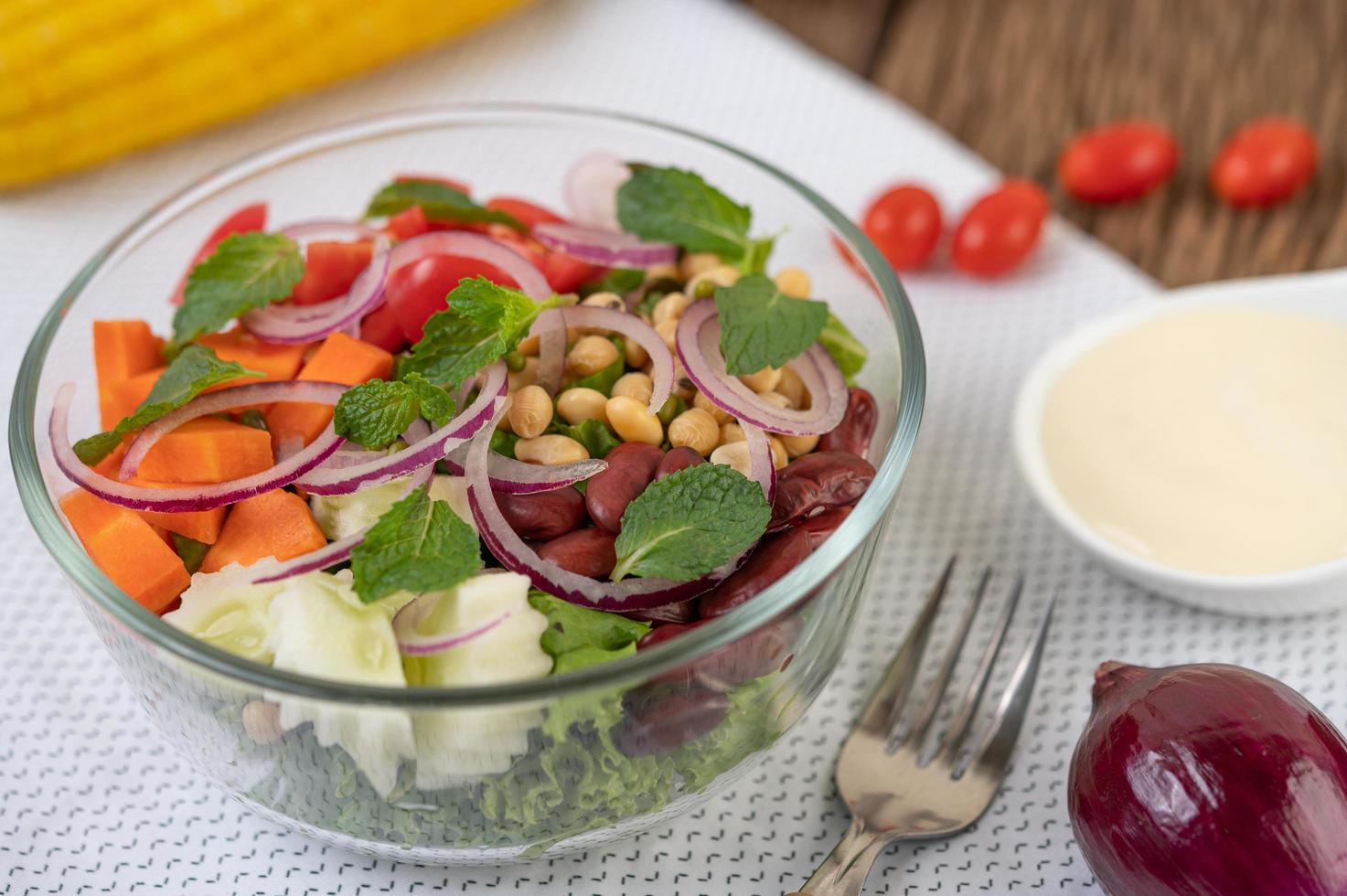 insalata di frutta e verdura fresca in una ciotola di vetro foto