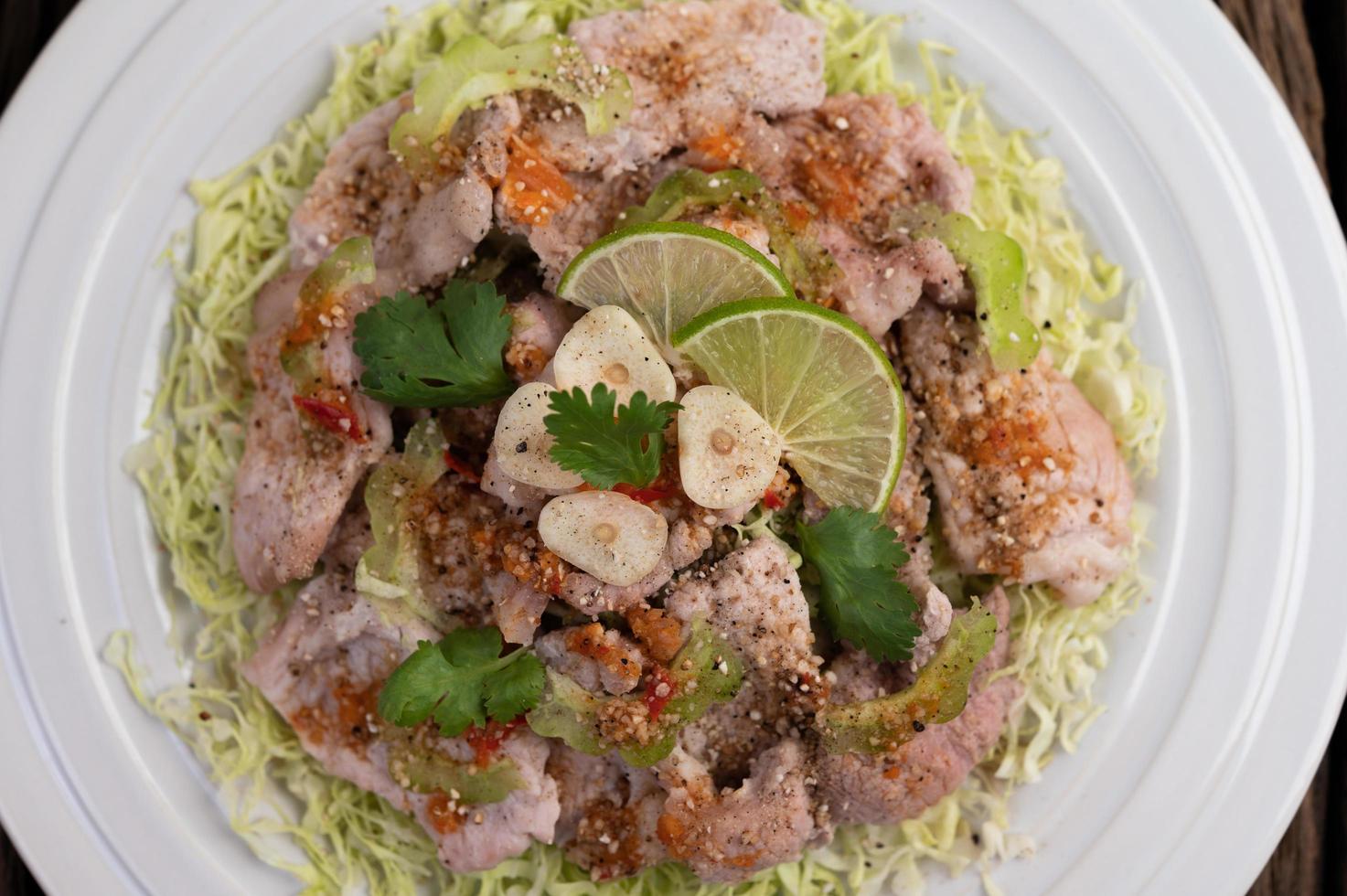 insalata di maiale piccante al lime con galanga, peperoncino e pomodori foto