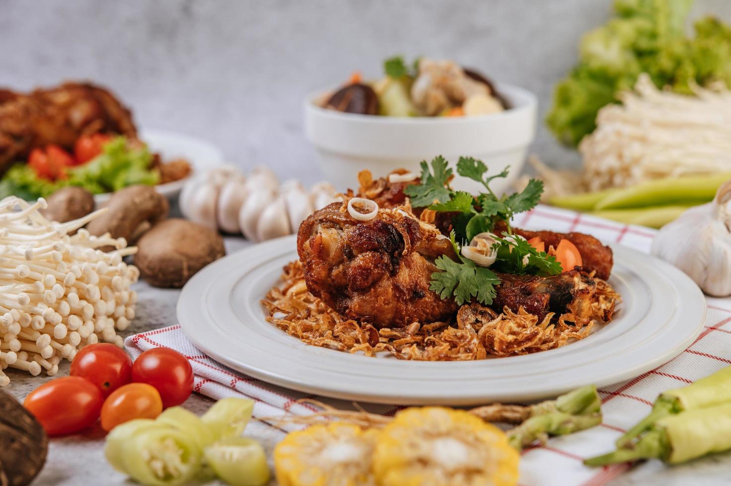 cosce di pollo fritte con pomodoro, peperoncino, cipolla fritta, lattuga, mais e funghi foto