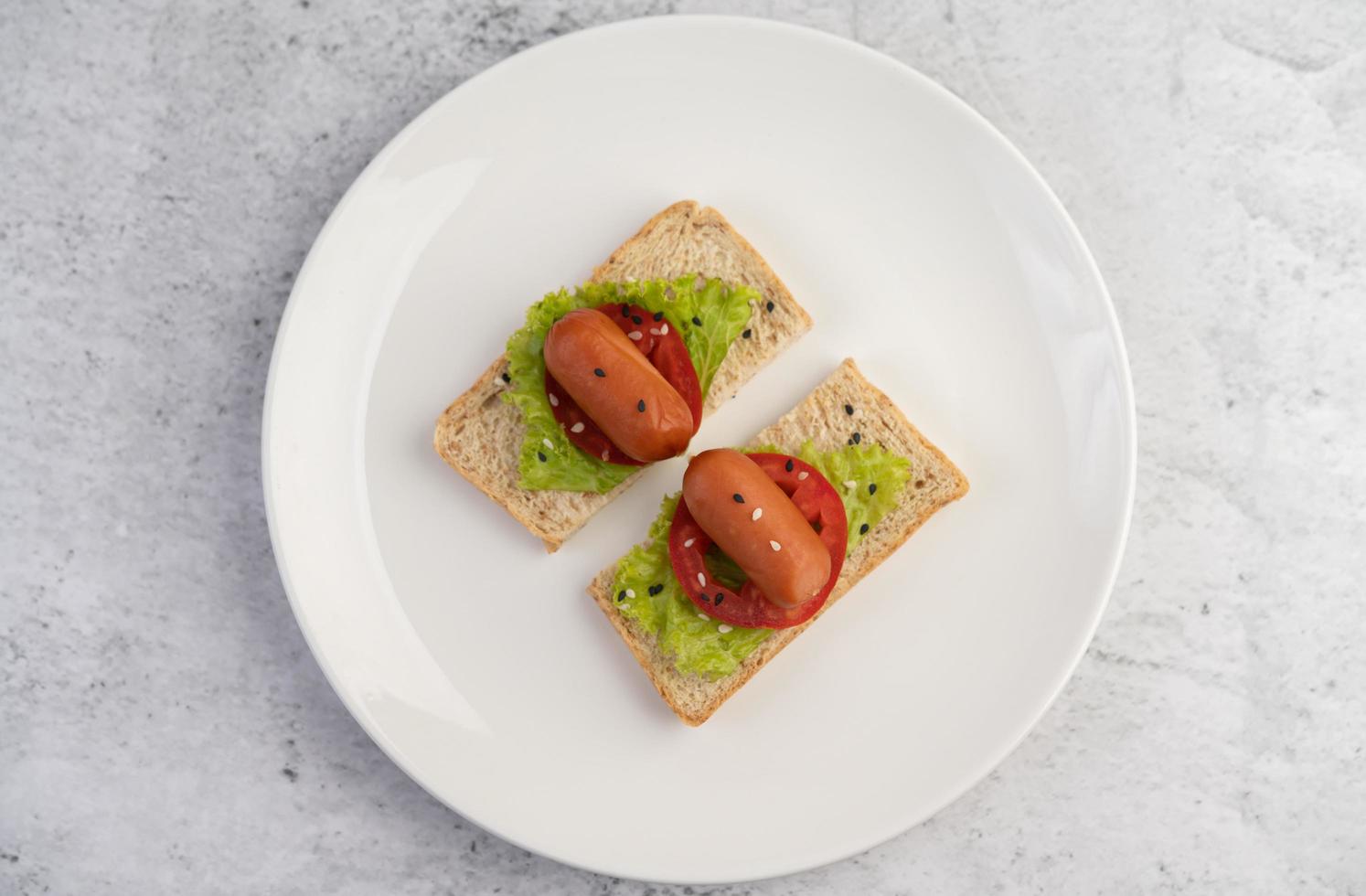 salsiccia con pomodori e insalata su pane foto