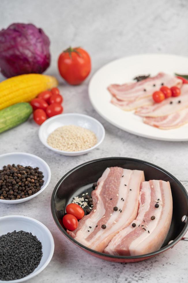 pancetta di maiale in padella con semi di pepe, pomodori e spezie foto