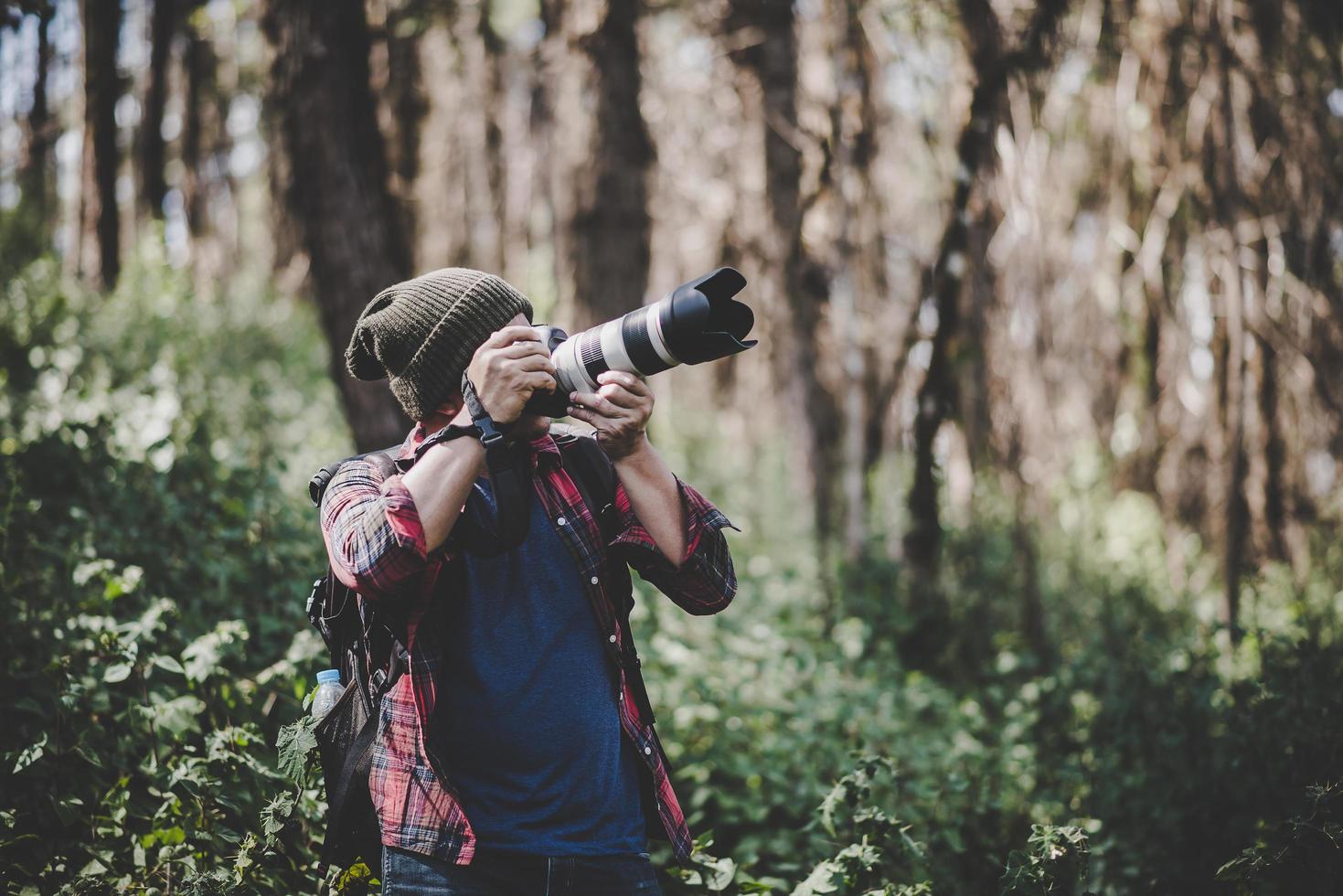 giovane fotografo che scatta foto nella foresta