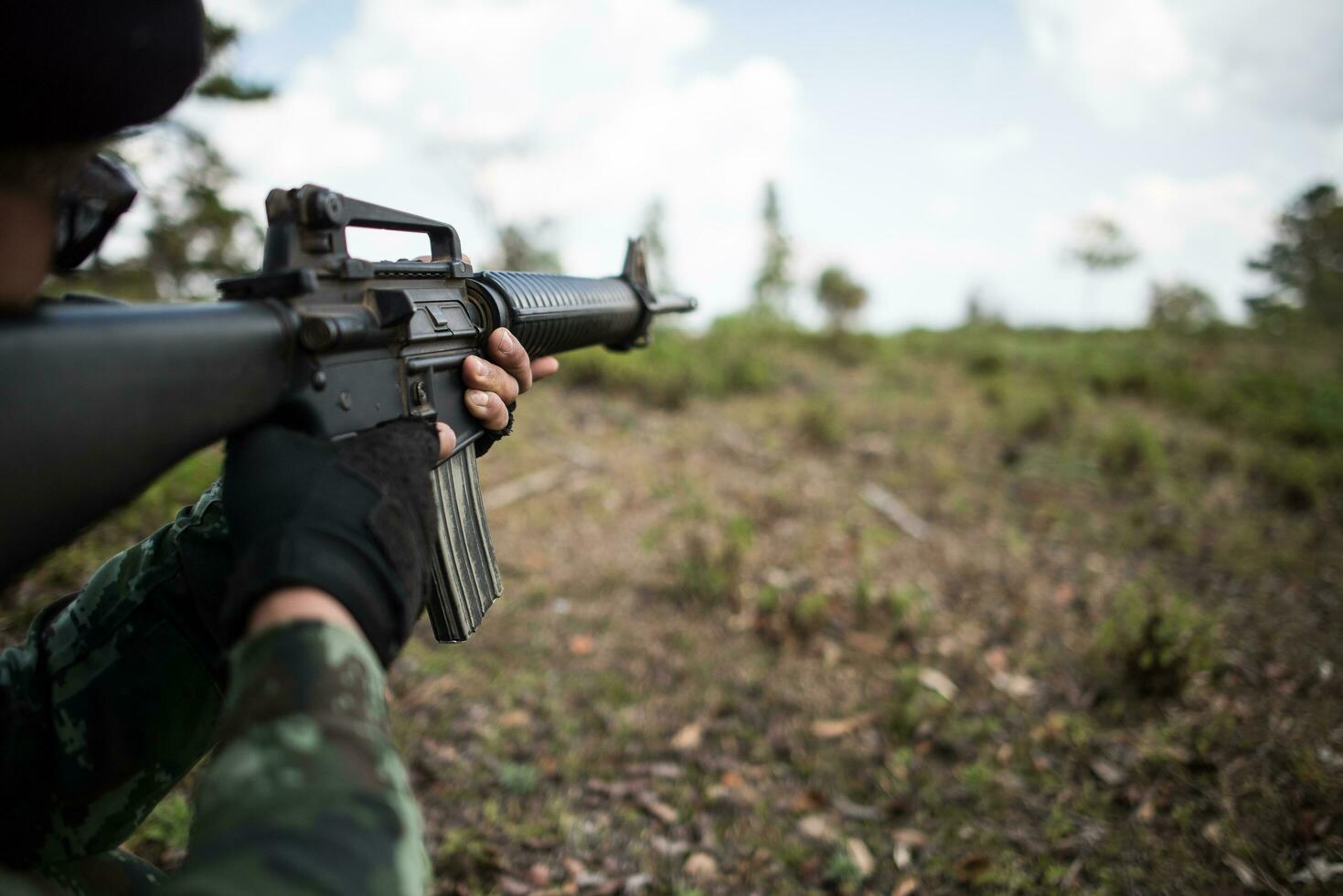 vero soldato mimetizzato che mira la loro arma foto