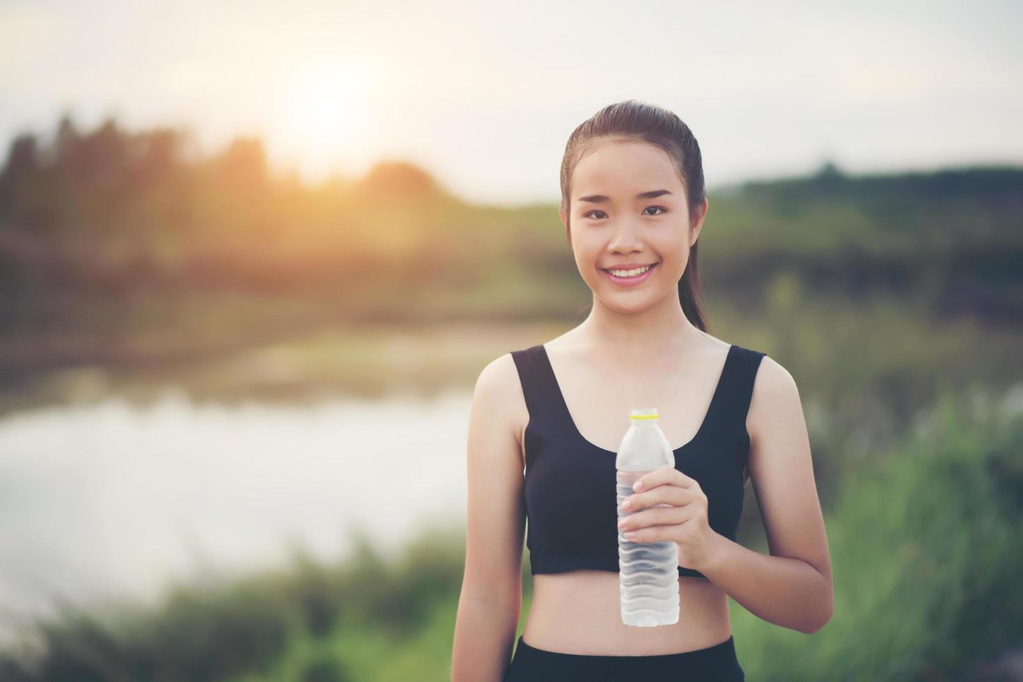 giovane adolescente fitness tenendo la bottiglia d'acqua dopo aver eseguito l'esercizio foto