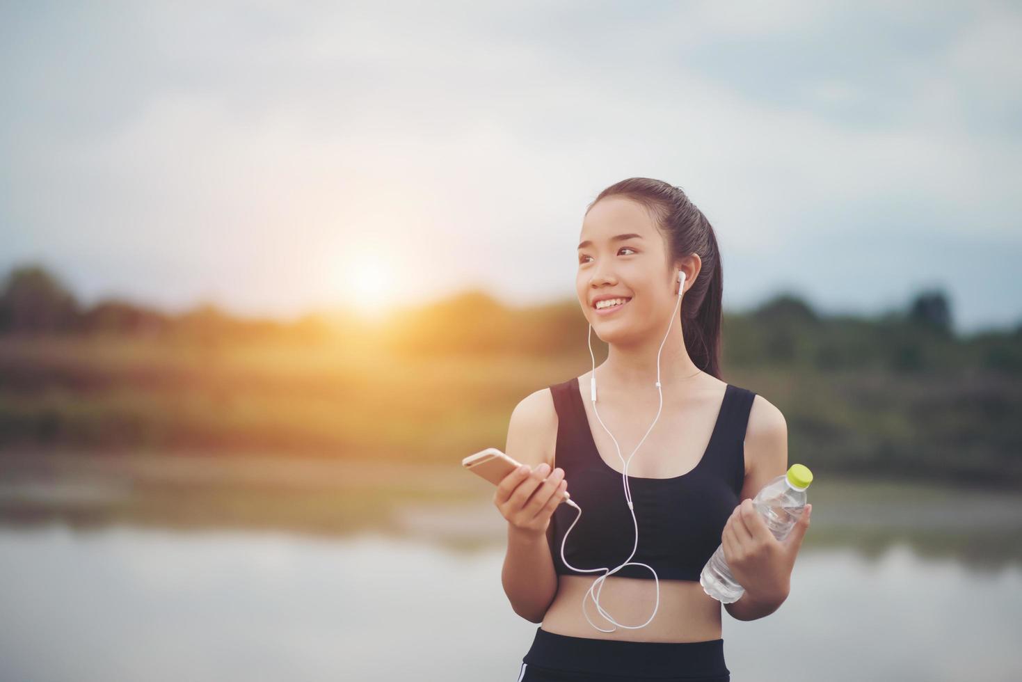 adolescente fitness con auricolari ascoltando musica durante il suo allenamento foto