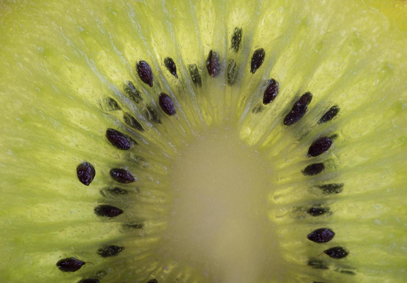 fetta di kiwi fresco maturo. frutta verde, vista dall'alto. metà del kiwi. cibo sano vegano o vegetariano, concetto di dieta. vitamina C. foto