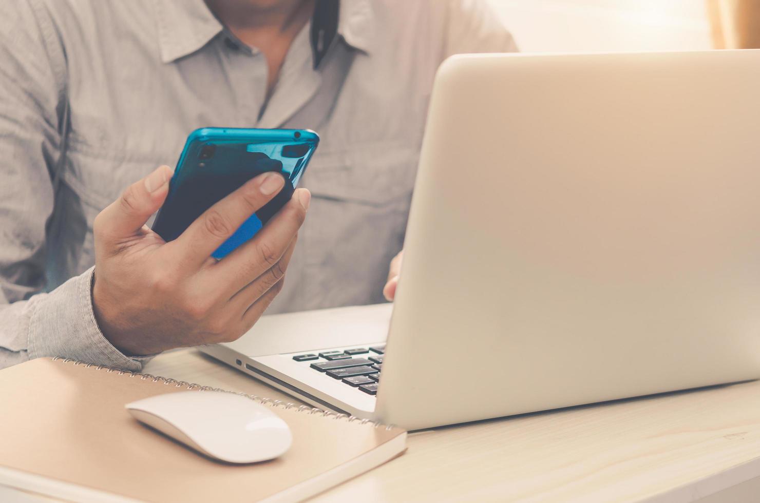 lavorare a casa con un laptop e un telefono foto