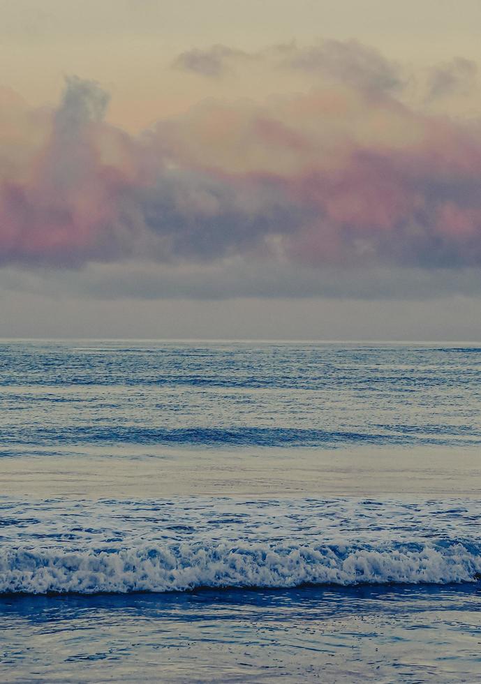 onde dell'oceano che si infrangono sulla riva durante il tramonto foto