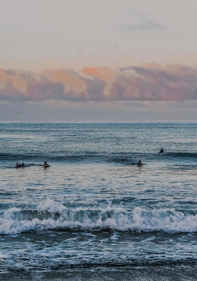 persone che navigano sulle onde del mare durante il giorno foto