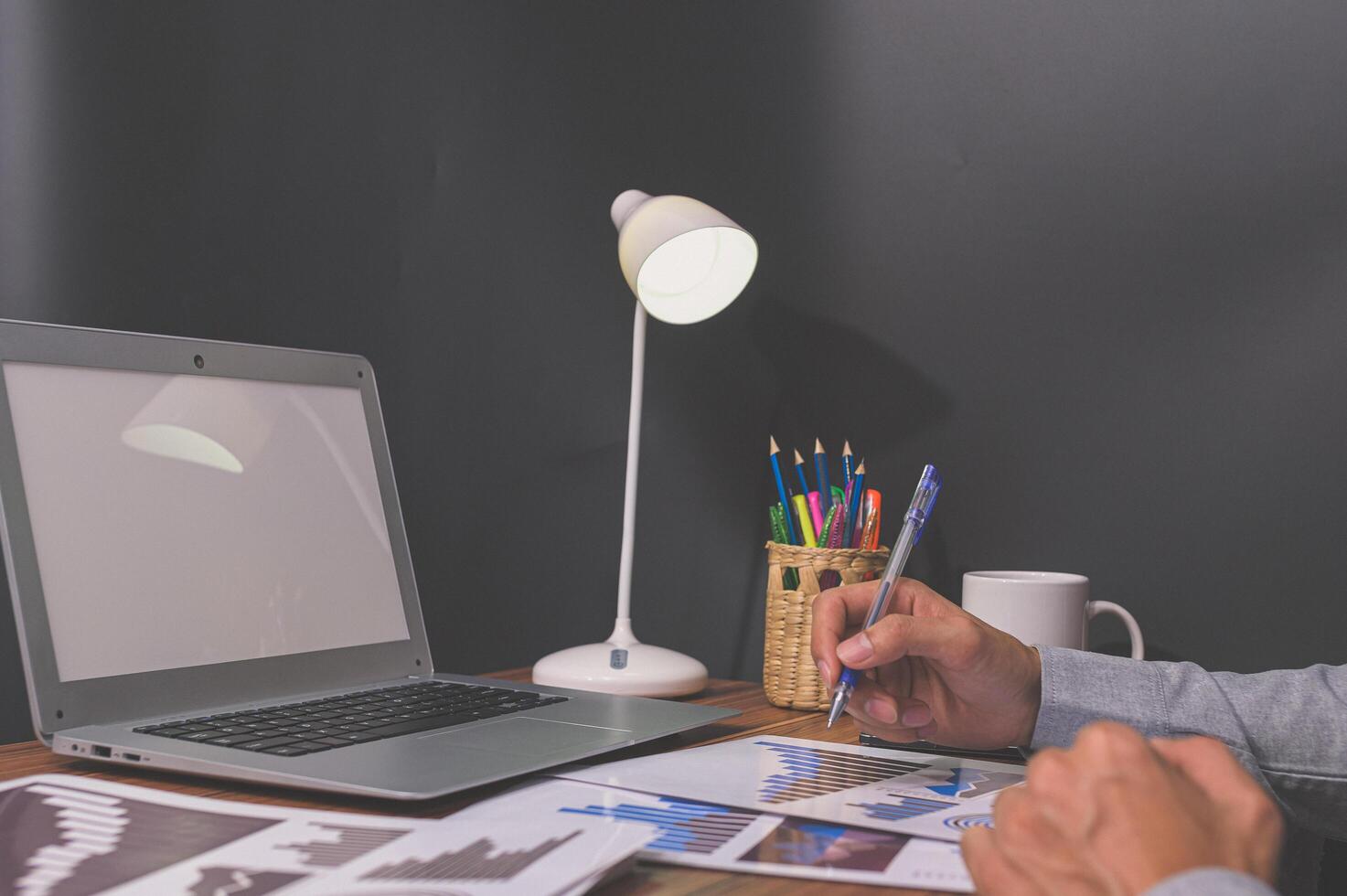 gli uomini d'affari si siedono al lavoro e controllano i documenti alla scrivania in camera foto