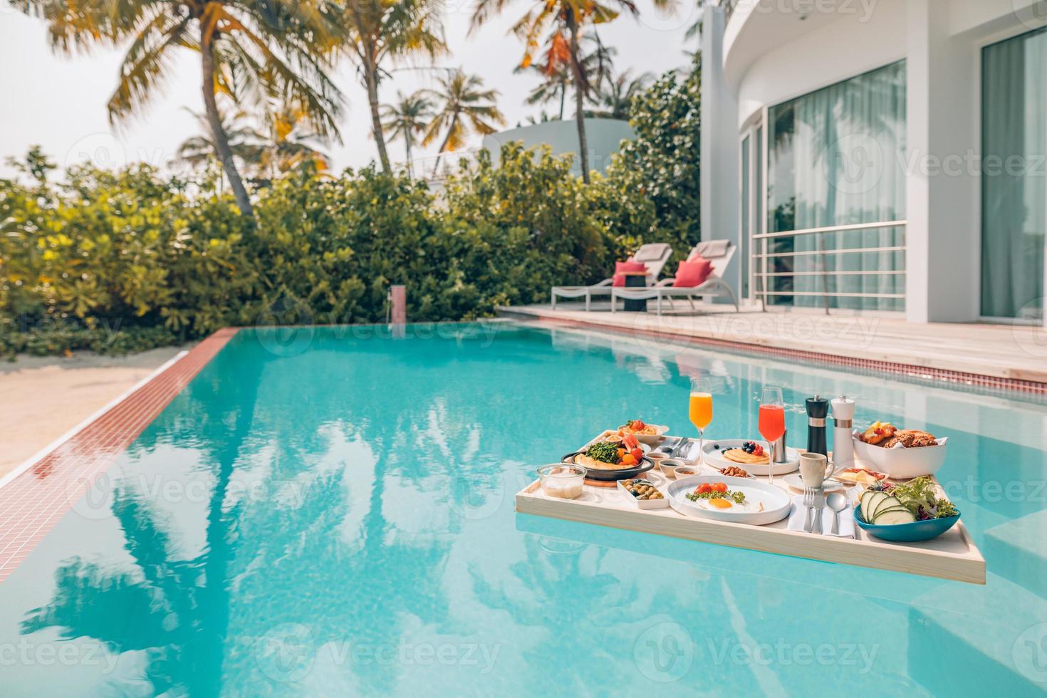 colazione in piscina, colazione galleggiante in un lussuoso resort tropicale. tavolo rilassante sull'acqua calma della piscina, colazione sana e piatto di frutta presso la piscina del resort. stile di vita di lusso da spiaggia tropicale foto