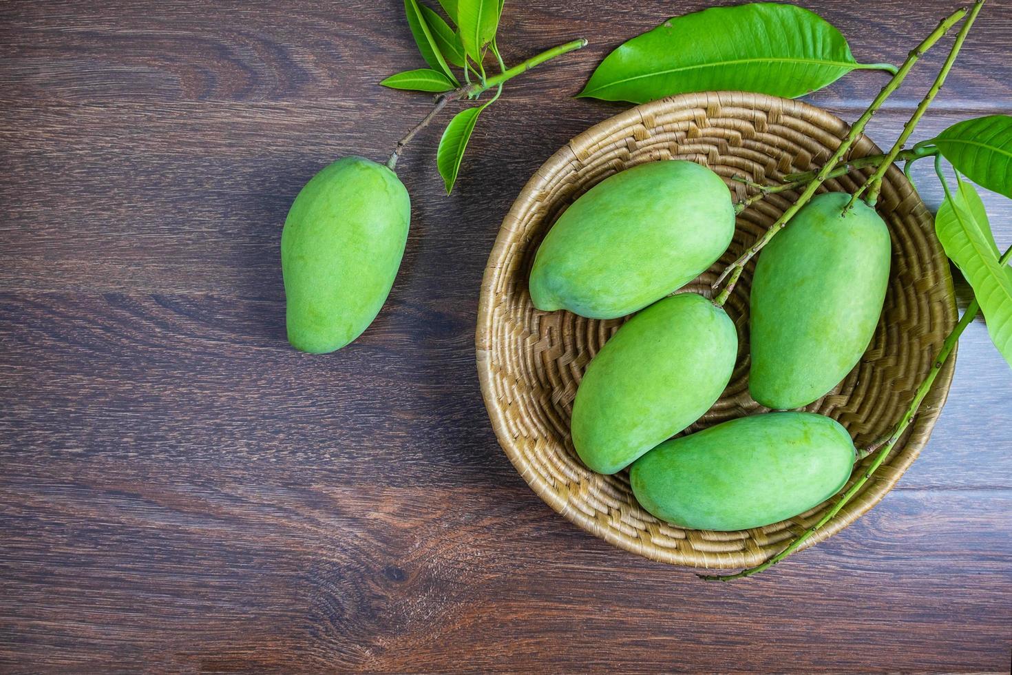 frutta fresca di mango verde in un cestino di legno foto