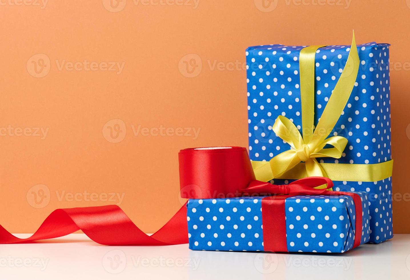 scatole confezionato nel festivo blu carta e legato con seta nastro su bianca sfondo, compleanno regalo, sorpresa foto