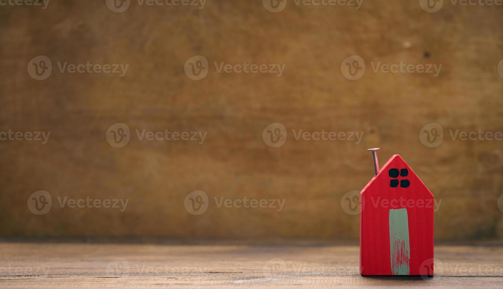 rosso di legno Casa su un' Marrone sfondo. vero tenuta noleggio, Acquista e vendita concetto. agente immobiliare Servizi, edificio riparazione e Manutenzione foto