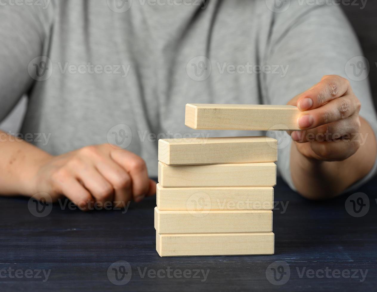 femmina mano mette di legno blocchi su superiore di ogni Altro. obbiettivo pianificazione concetto, nuovo conoscenza foto