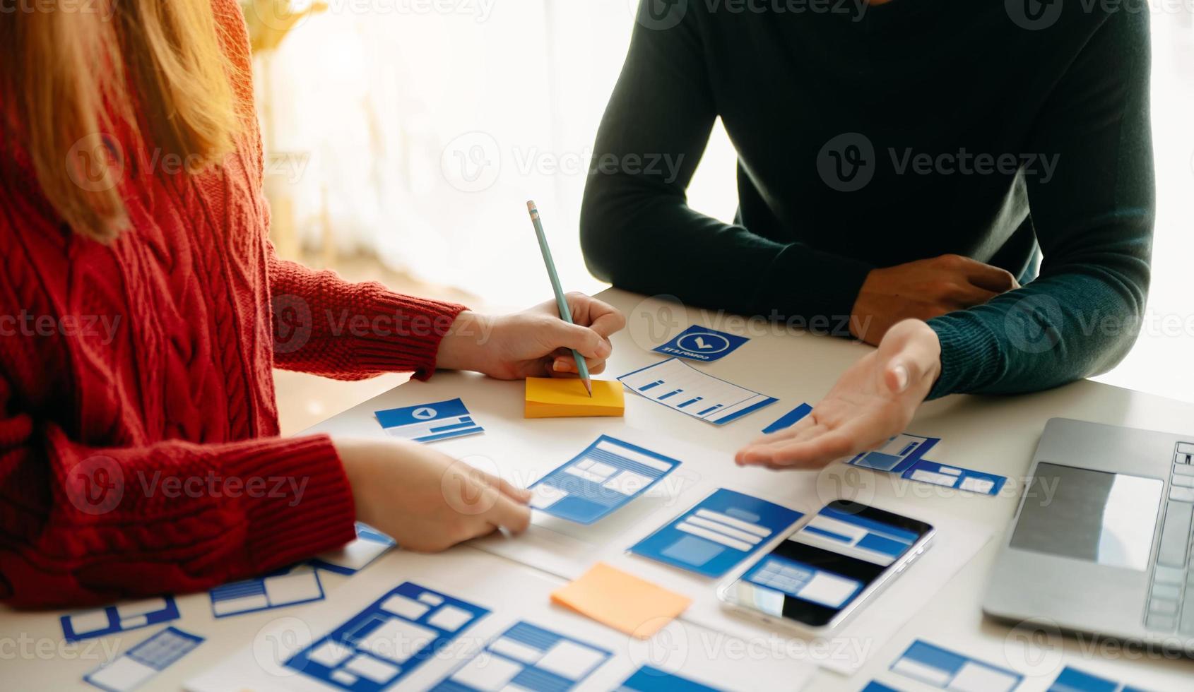 vicino su Visualizza di ui sviluppatore squadra di brainstorming su loro progetto con computer portatile, smartphone e digitale tavoletta. creativo digitale sviluppo agenzia. foto