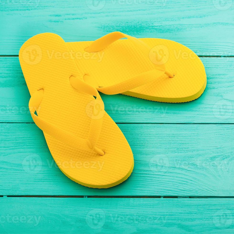 giallo Flip flop su blu di legno sfondo. estate vacanze. superiore Visualizza. finto su. copia spazio foto