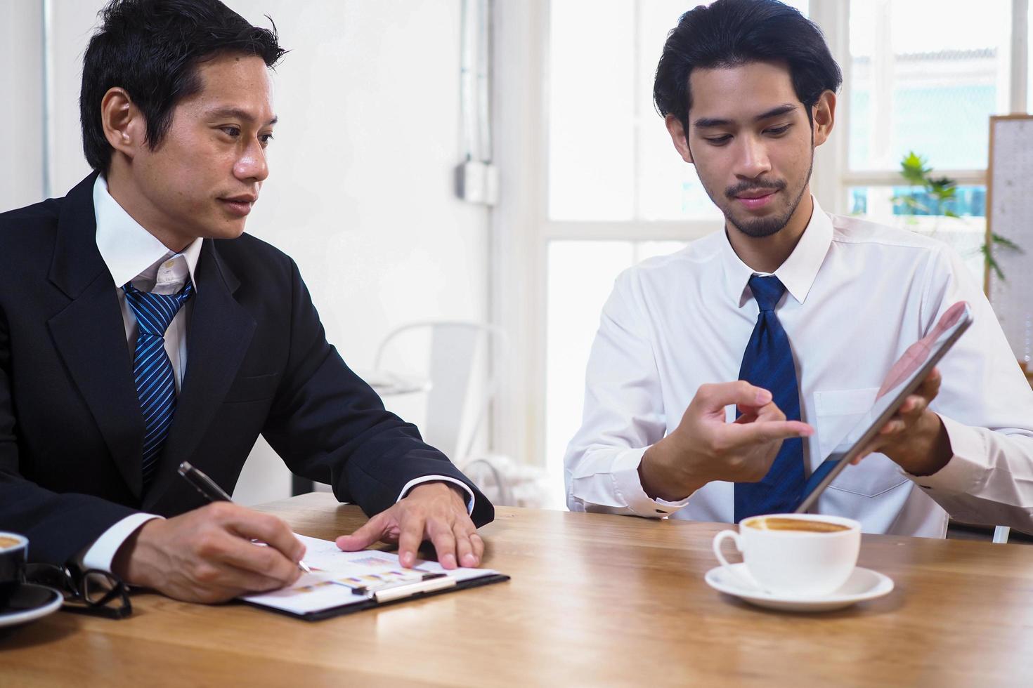 asiatico consulenti analizzare e discutere attuale economico situazione. ottenere finanziario consigli e investire nel azioni di banche o aziende quello siamo nel il azione mercato. foto