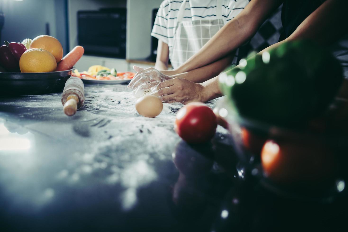 piccolo chef che usa il mattarello per stendere la pasta foto