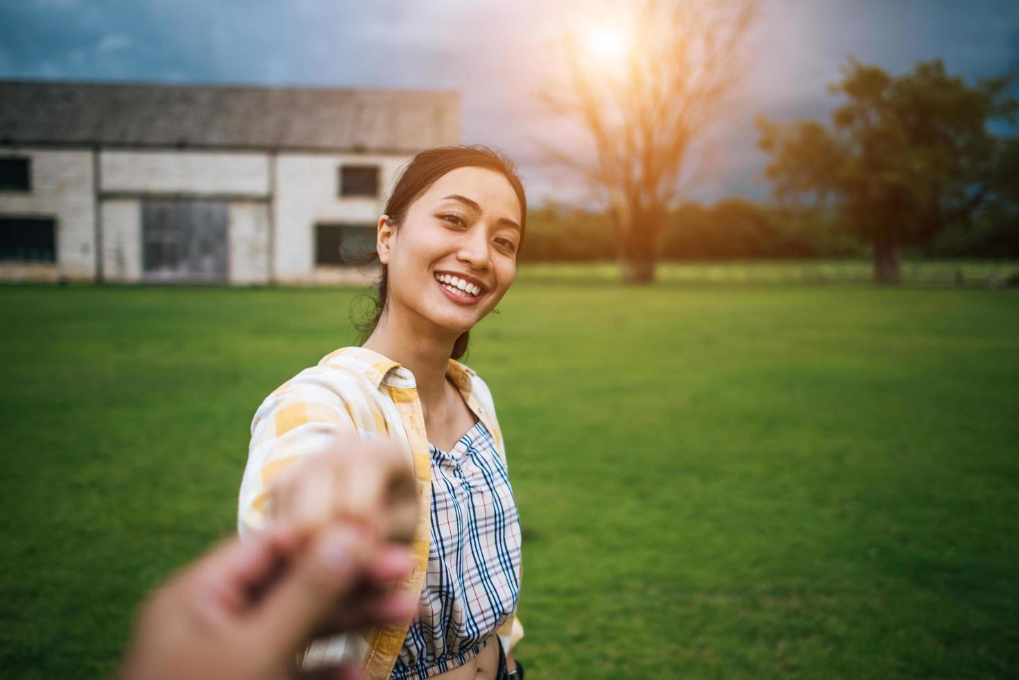 donna che cammina e tiene la mano del fidanzato che la segue foto