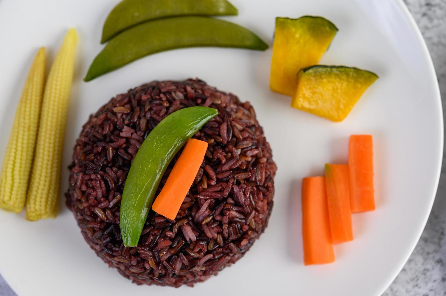 riso nero con zucca, piselli, carote e baby mais foto