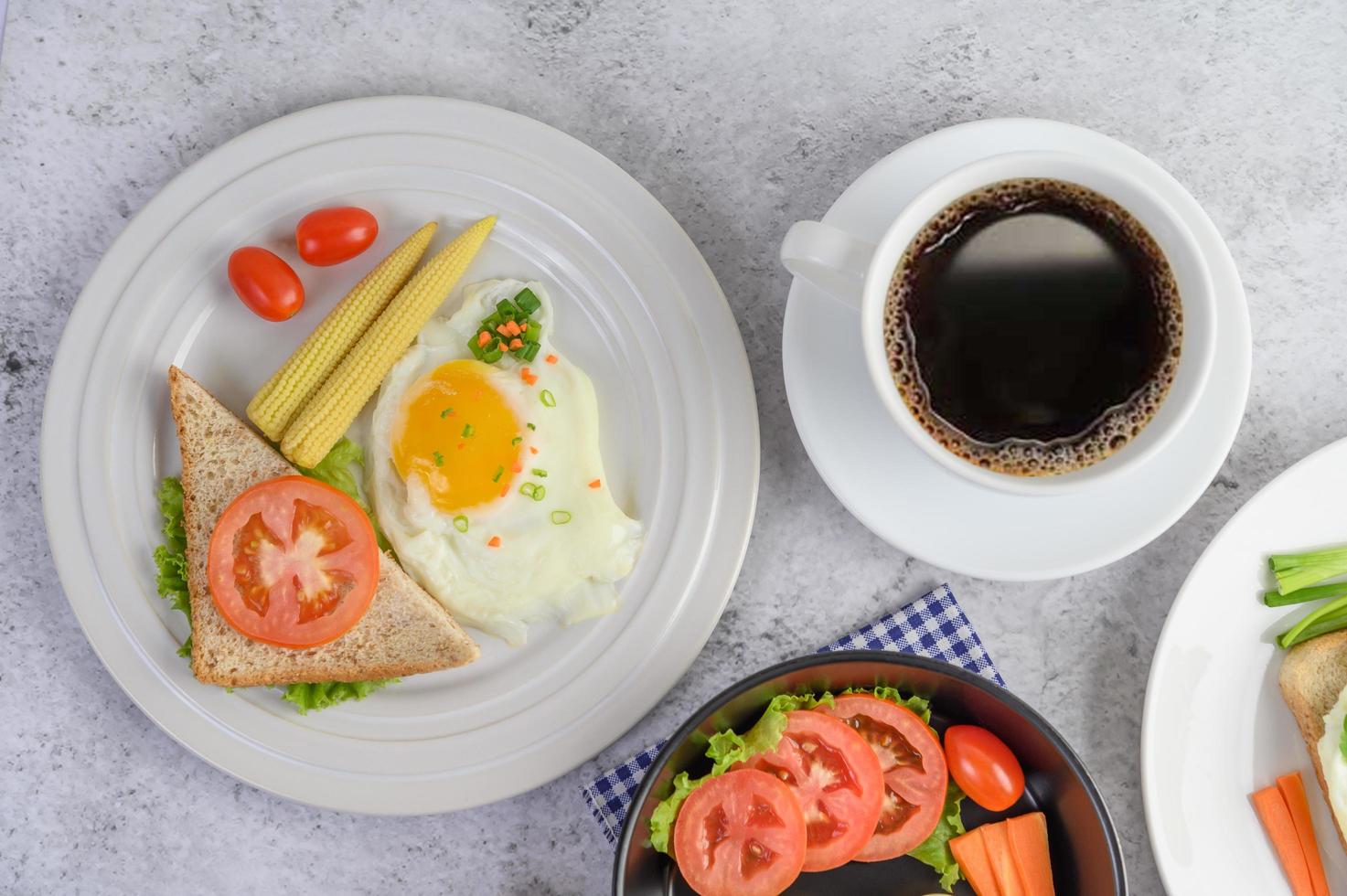 uova sode, carote e pomodori con cucchiaio e tazza di caffè foto