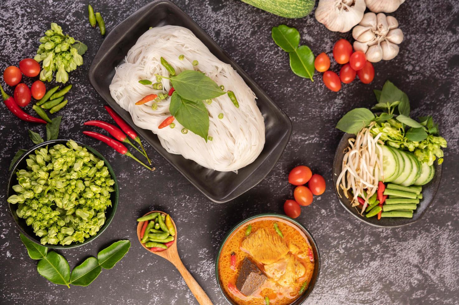 pollo al curry in una tazza nera con spaghetti di riso foto