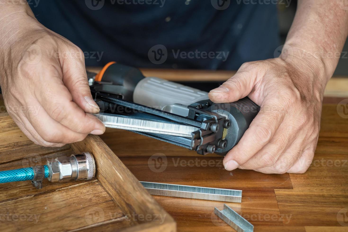 falegname che usa una pistola sparachiodi ad aria che fa lavori di mobili  in legno 9297795 Stock Photo su Vecteezy