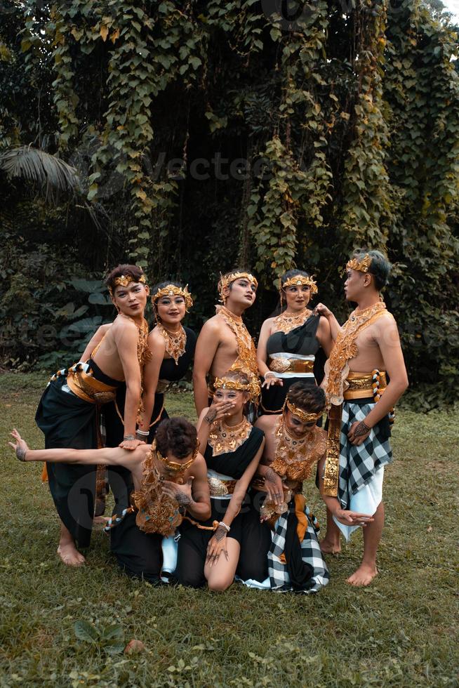 un' mazzo di asiatico persone avendo divertimento mentre assunzione un' foto sparare con un' d'oro danza costume nel davanti di il giungla