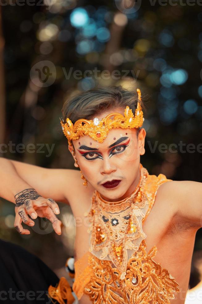 balinese viso nel trucco e indossare un' d'oro corona e d'oro collana prima il danza prestazione iniziò foto