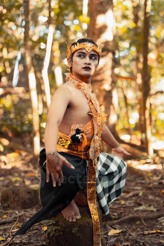 un' tribale uomo pose con trucco su sua viso mentre indossare oro Accessori su il suo testa e collo foto