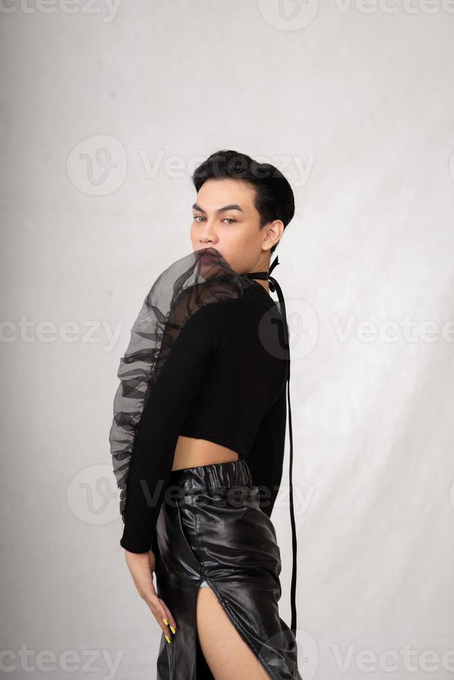 asiatico uomo pose nel un' nero costume mentre indossare trucco e nero capelli foto