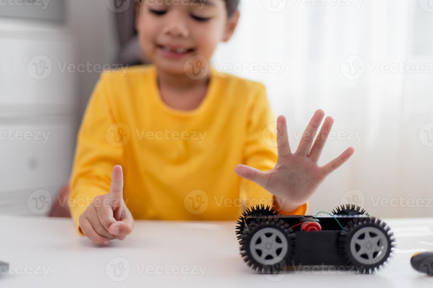 gli studenti asiatici imparano a casa a codificare auto robot e cavi di schede elettroniche in stelo, vapore, matematica ingegneria scienza tecnologia codice informatico in robotica per bambini concetto. foto