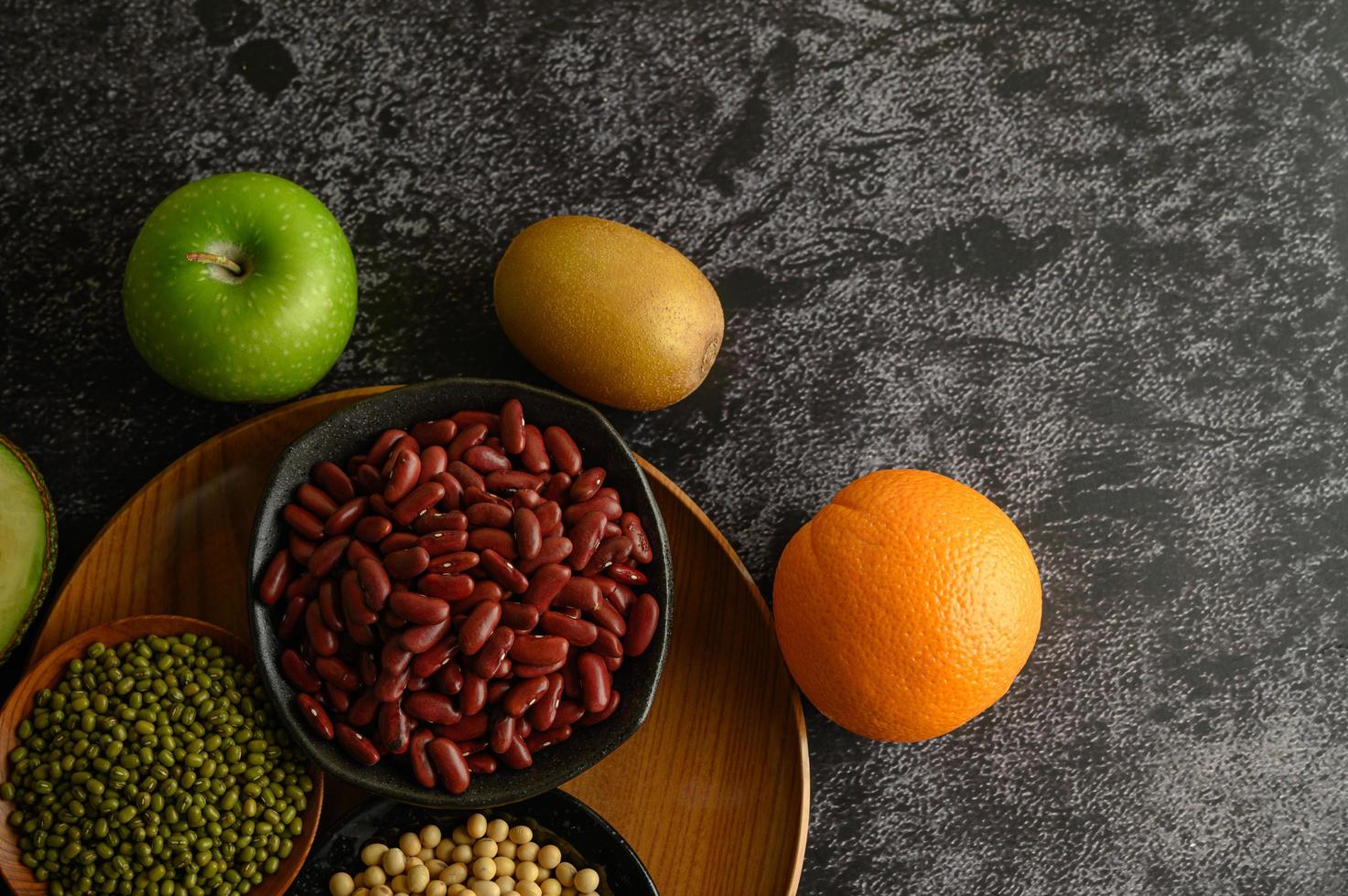 legumi e frutta su fondo scuro foto