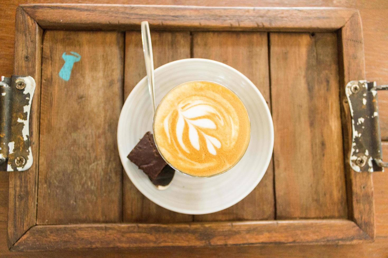 caffè con latte art e brownie sul piatto di legno foto