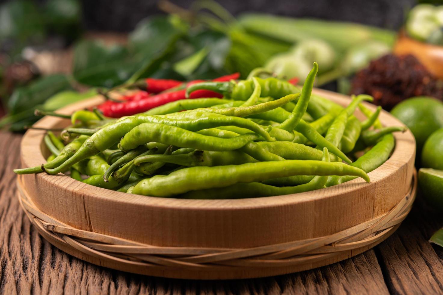 peperoncino fresco su un vassoio di legno con limone e lime kaffir foto