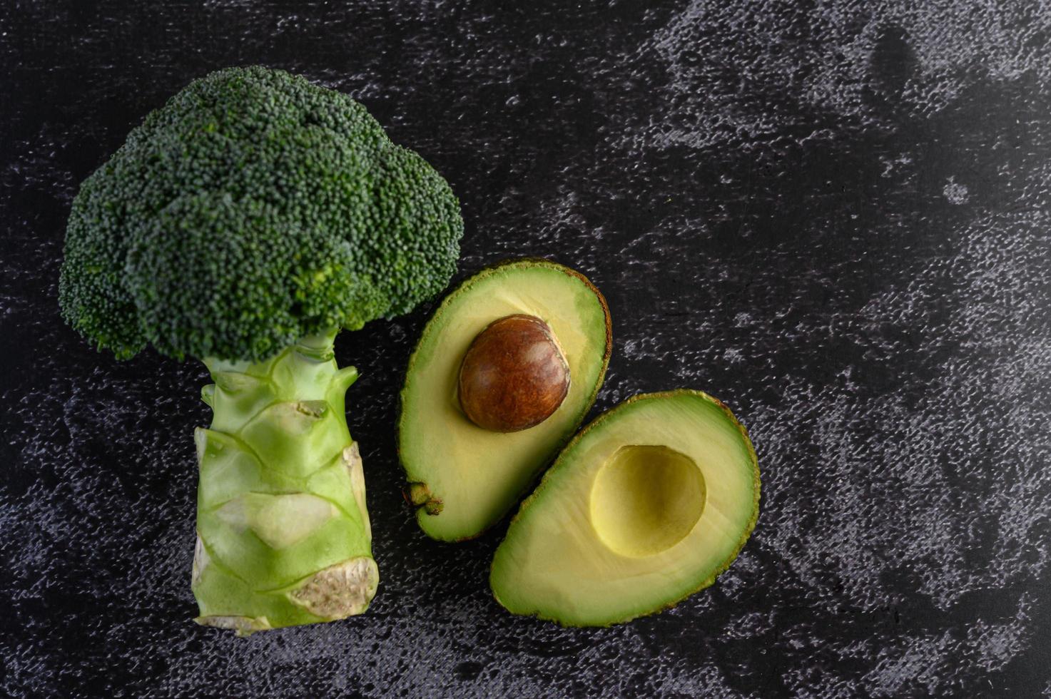 broccoli e avocado su sfondo nero pavimento di cemento foto