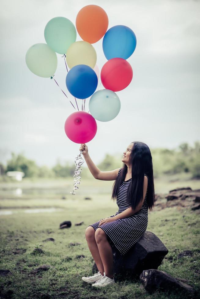 giovane donna che tiene palloncini colorati in natura foto