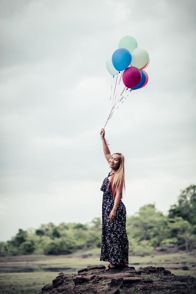 giovane donna che tiene palloncini colorati in natura foto