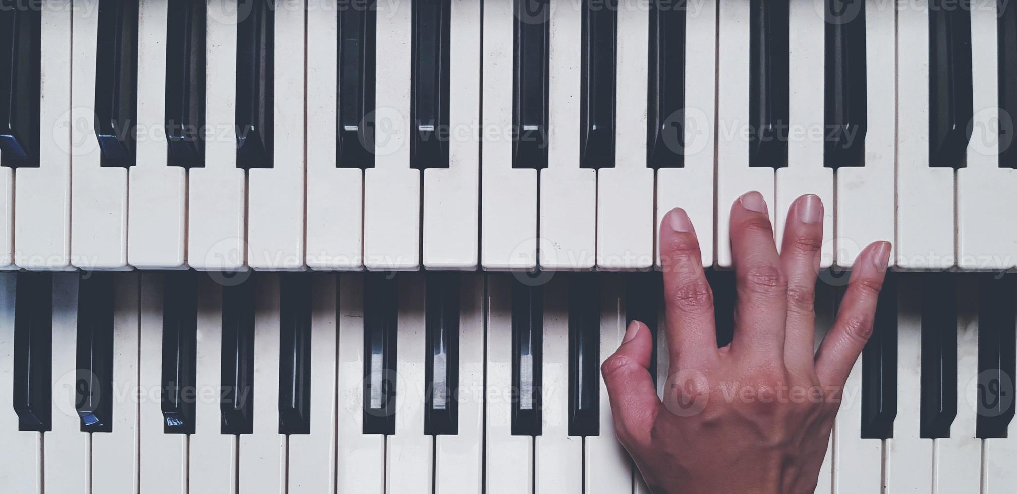 superiore Visualizza di mano giocando pianoforte o eleggere tono tastiera nel Vintage ▾ colore stile. oggetto, musica e strumento concetto foto