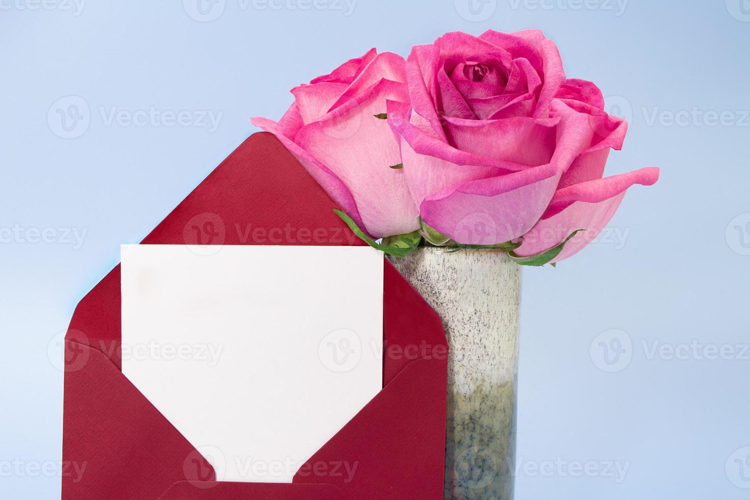 rosso Busta con posto di carta per testo e vaso di rosa Rose su blu sfondo. invito, compleanno, marzo 8, internazionale Da donna, La madre di giorno. copia spazio foto